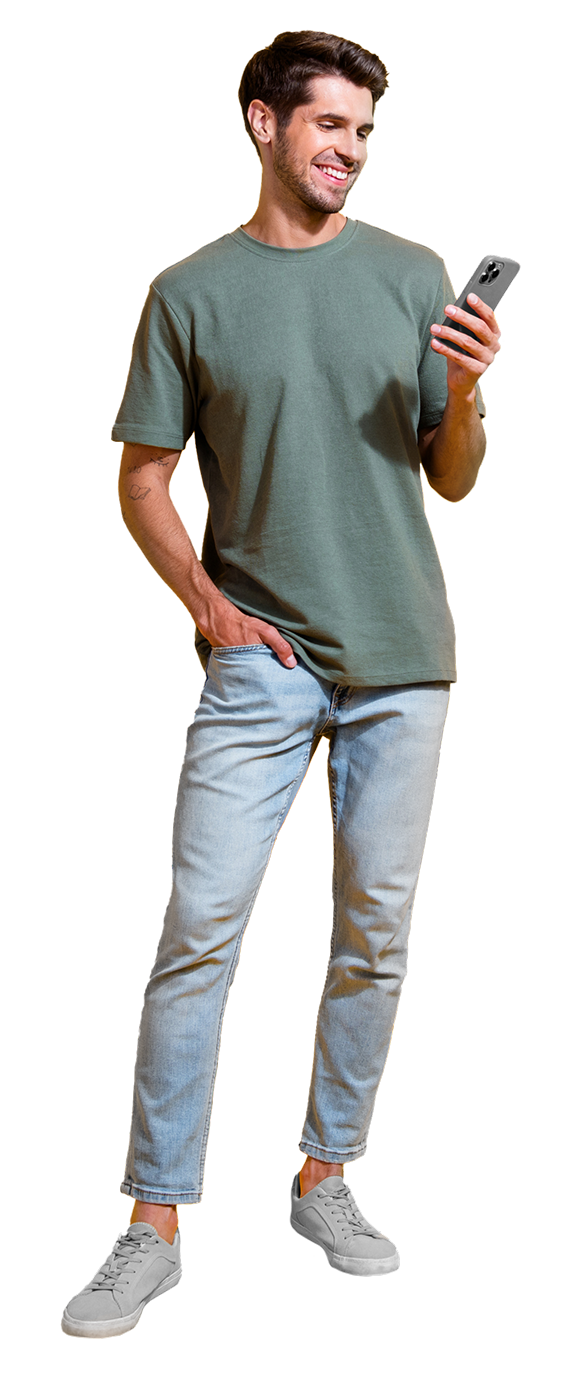 Un homme en jeans et t-shirt vert tient un téléphone portable.